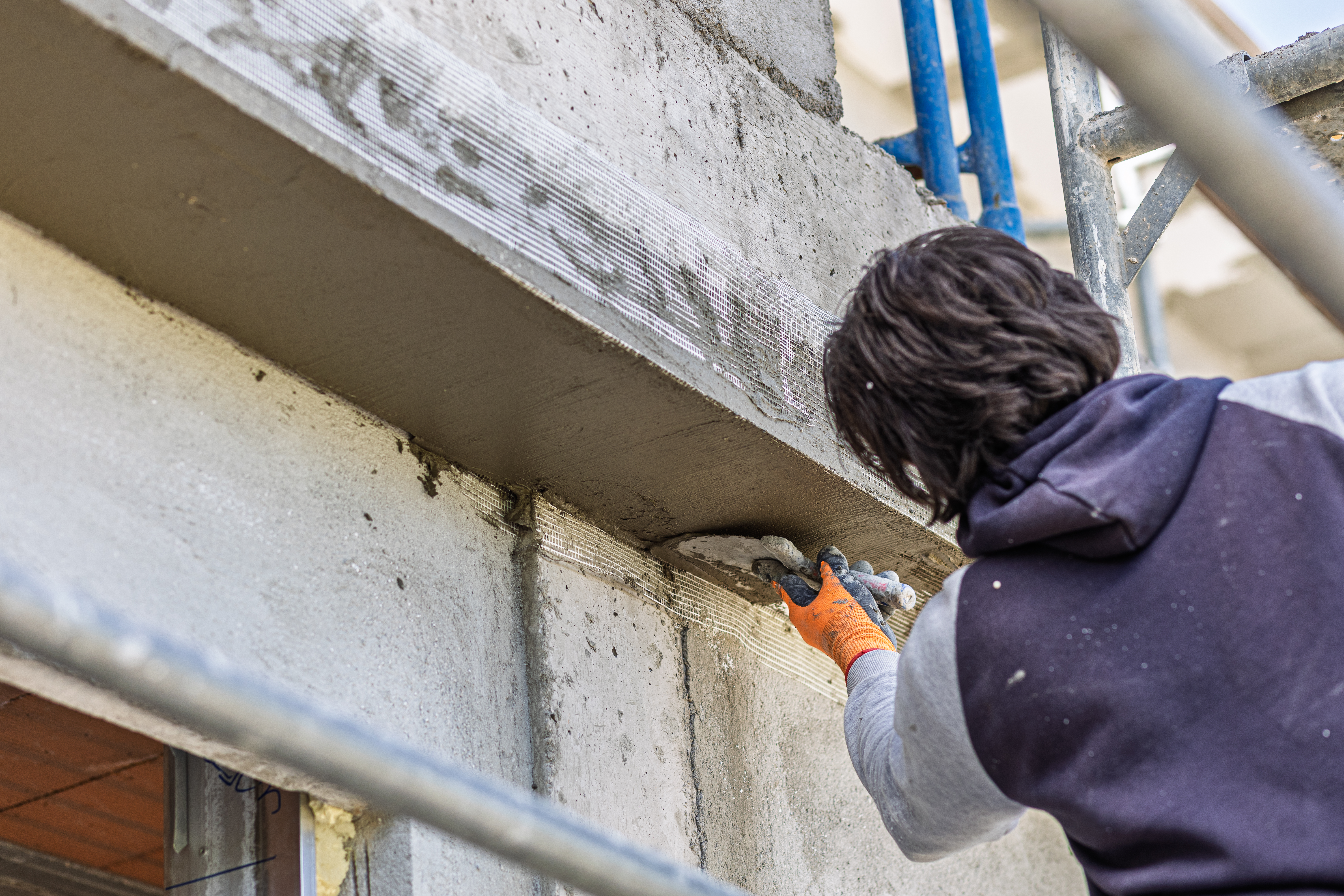 Man applying fresh mortar to a building facade on a construction site